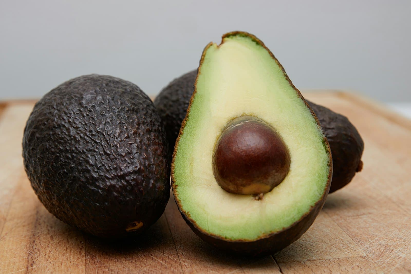 Fuerte avocado sliced on a wooden surface